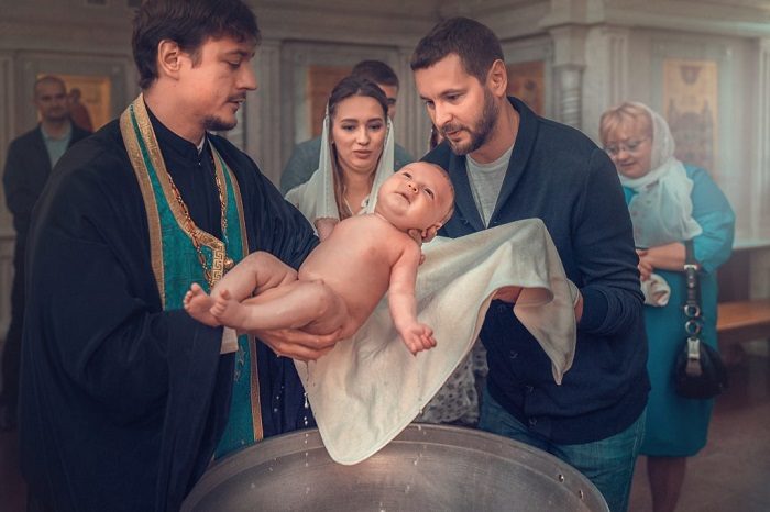 Ребенок извлекается из крестильной купели